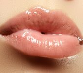 Glossy, pink lips close-up, with visible texture and shine.